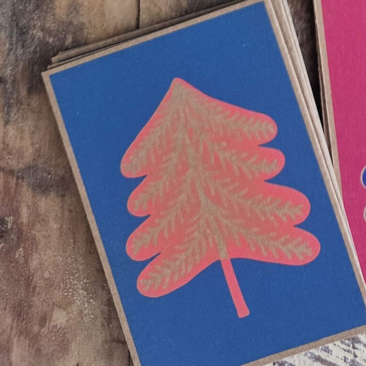Karte «Tannenbaum» von Märchenprints: Tannenbaum in Koralle auf blauem Karton, am Rand brauner Karton