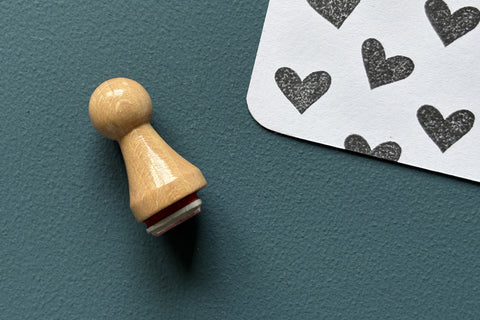 Mini-Stempel «Herz» von Mare di Maria – Holzstempel in Kegelform auf dunkelgrünem Grund, daneben schwarze Herz-Abdrücke auf weisser Karte