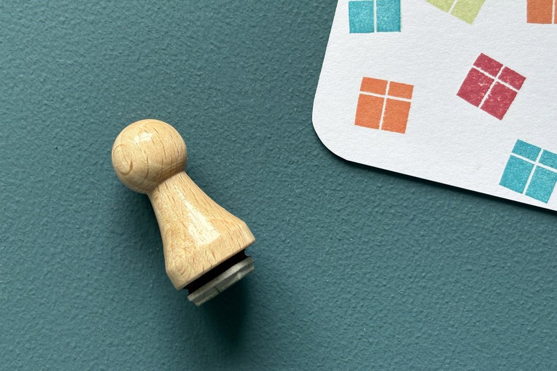Mini-Stempel «Geschenk» von Mare di Maria – Holzstempel neben Päckli-Abdrücken in Orange, Rot, Türkis und Grün auf weisser Karte