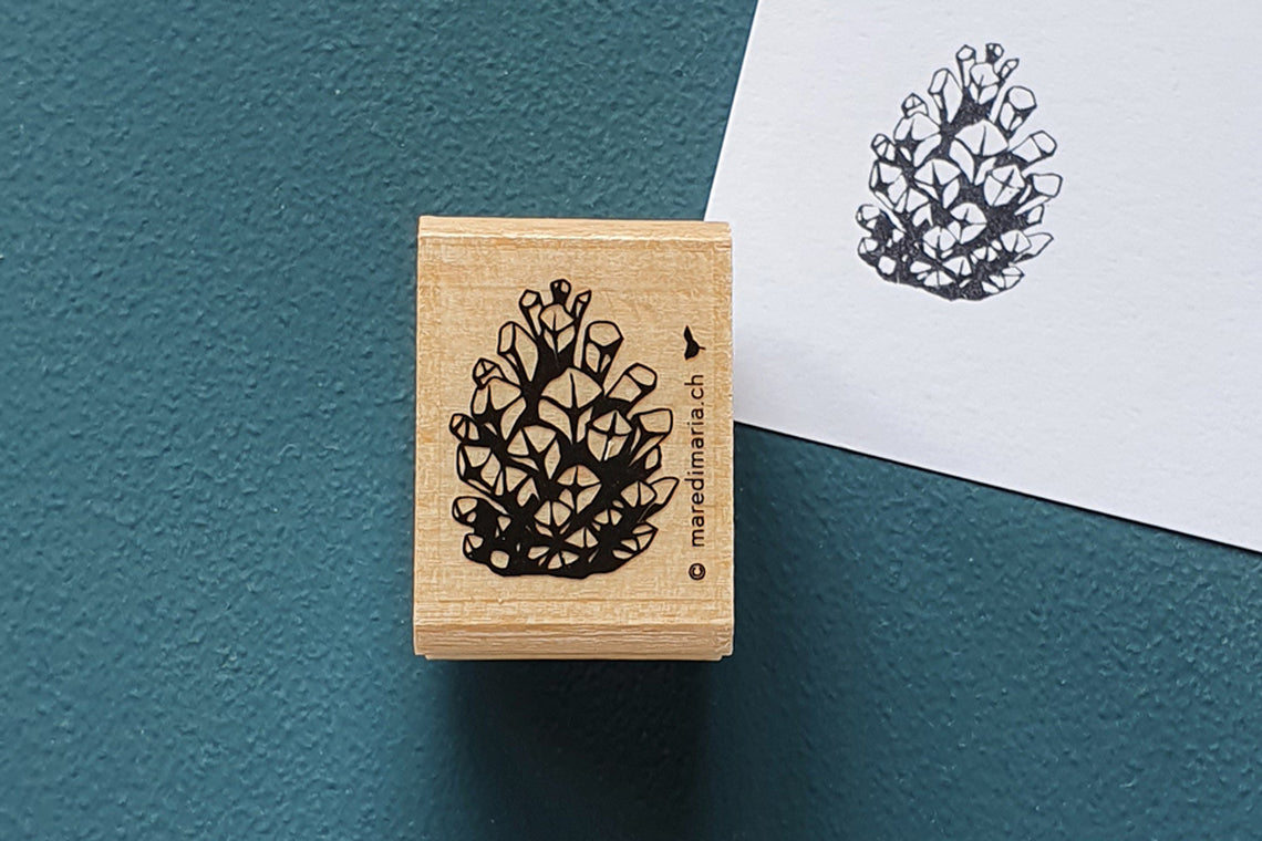 Holzstempel «Kleiner Zapfen» von Mare di Maria – rechteckiger Holzstempel mit Zapfen-Motiv auf dunkelgrünem Grund, daneben der schwarze Abdruck auf weissem Papier