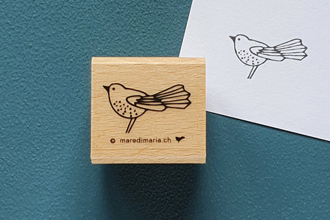 Holzstempel «Kleiner Vogel» von Mare di Maria – quadratischer Holzstempel mit Vogel mit Fächerschwanz auf dunkelgrünem Grund, daneben der schwarze Abdruck auf weissem Papier