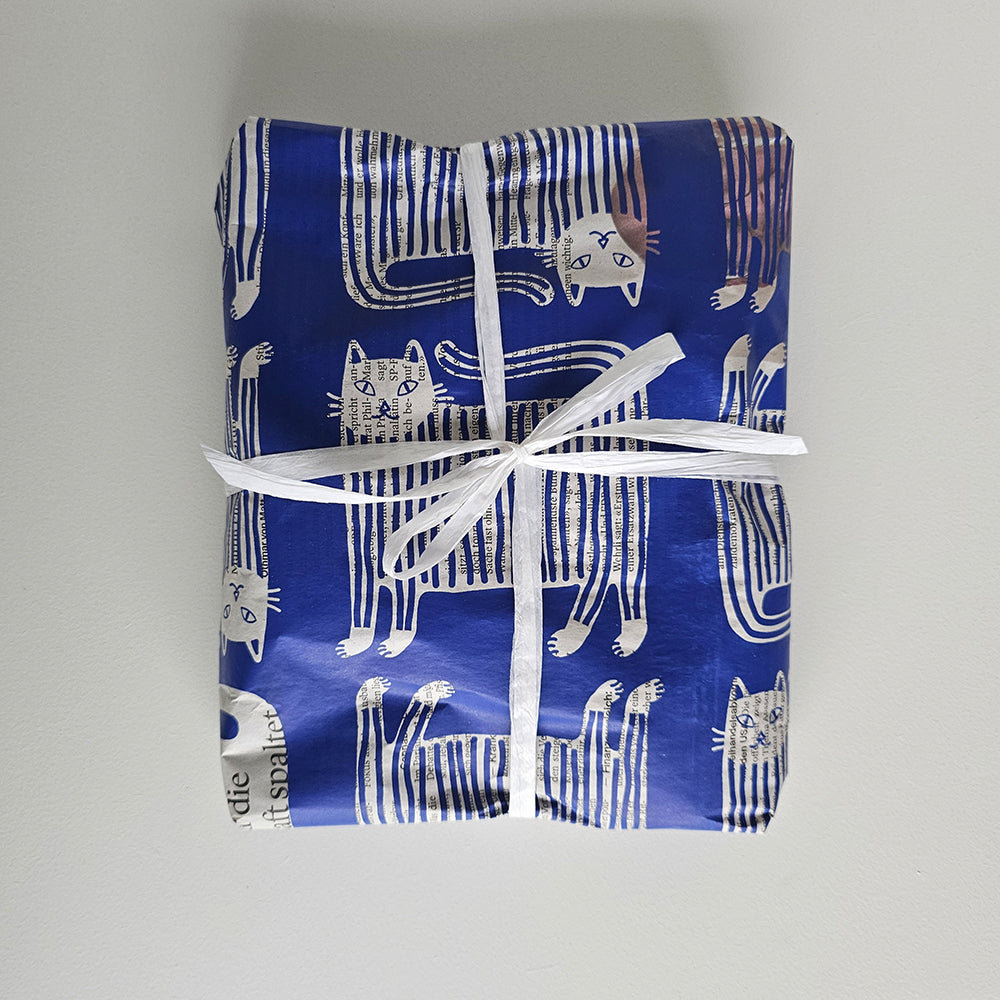 Present wrapped in «Puss in Boots» paper with a white ribbon