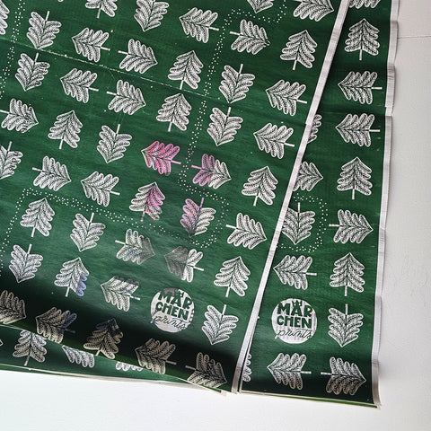 Wrapping paper «Hansel and Gretel» by Märchenprints laid out: fir trees, white on dark green, screen-printed on newspaper