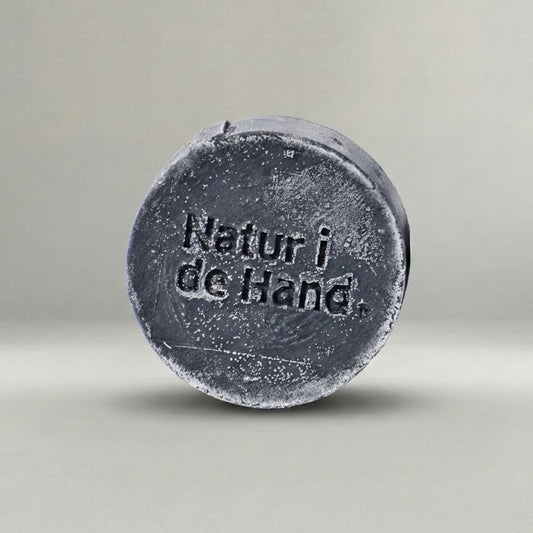 Naturseife Detox – anthrazitfarbene Seife mit Prägung «Natur i de Hand» in Nahaufnahme