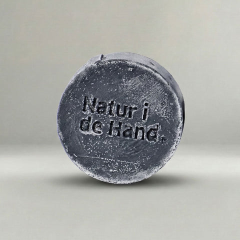 Naturseife Detox – anthrazitfarbene Seife mit Prägung «Natur i de Hand» in Nahaufnahme