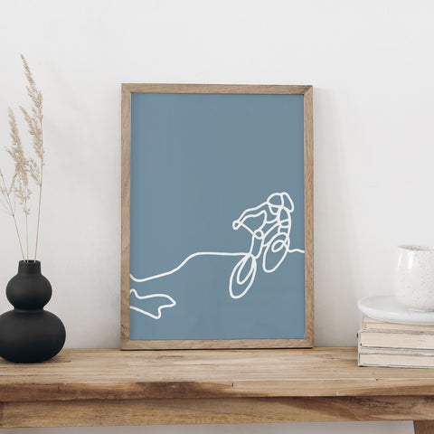 NaniManu Plakat «Biken» im Holzrahmen auf einer Holzkommode – Mountainbiker-Strichzeichnung als Wanddeko