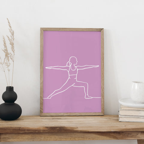 NaniManu Plakat «Yoga» im Holzrahmen auf einer Holzbank an weisser Wand, daneben schwarze Vase mit Trockengräsern und ein Bücherstapel mit Tasse