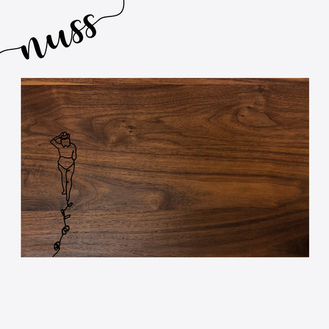 Schneidebrett Nussbaum Grösse M – Linienmotiv Frau mit Fussspur auf dunklem Holz – Vorderseite, grosses Format