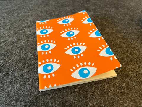 Notizheft Orange Augen A6 – All eyes on me