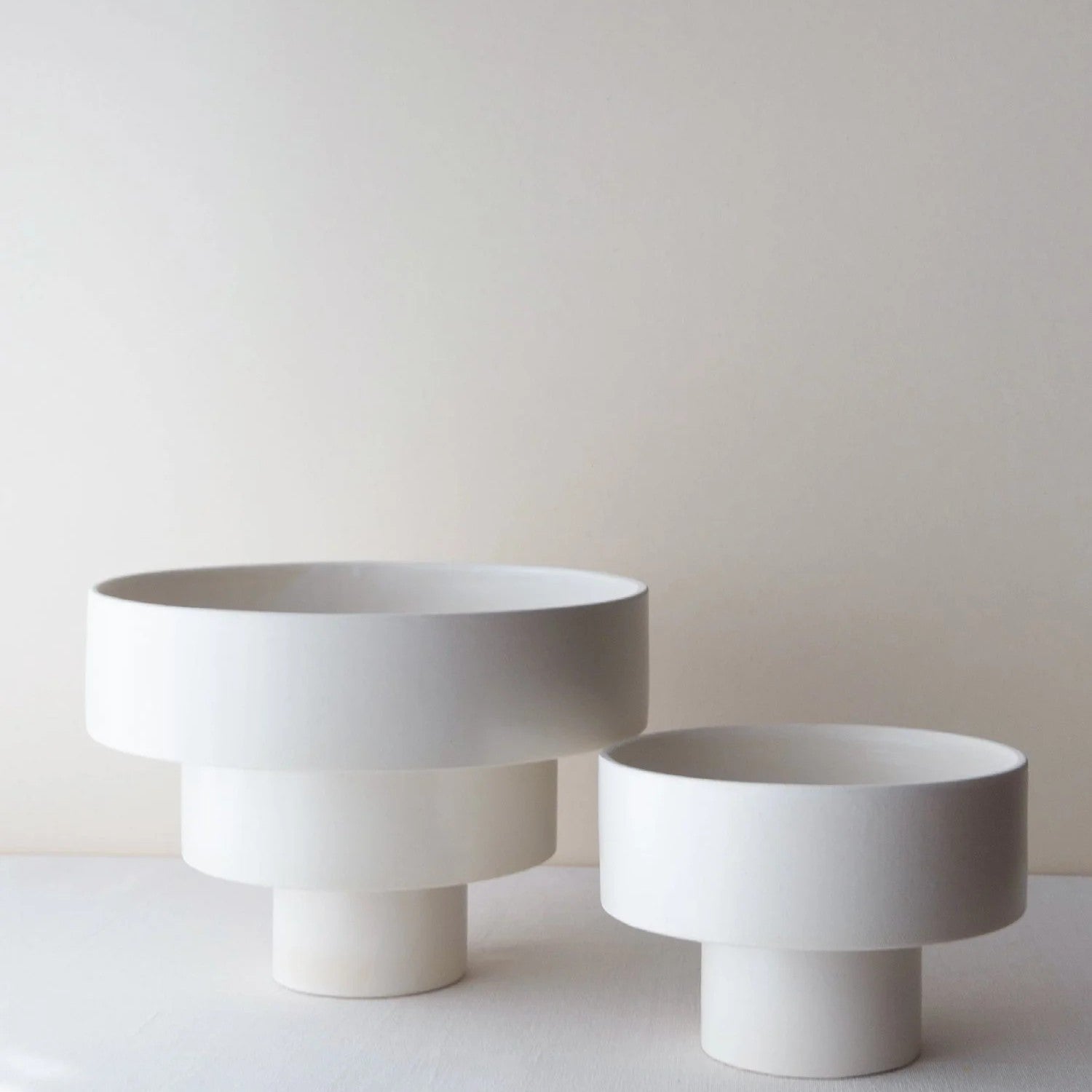 Two white STACK bowls side by side, the Large on the left, the smaller one on the right