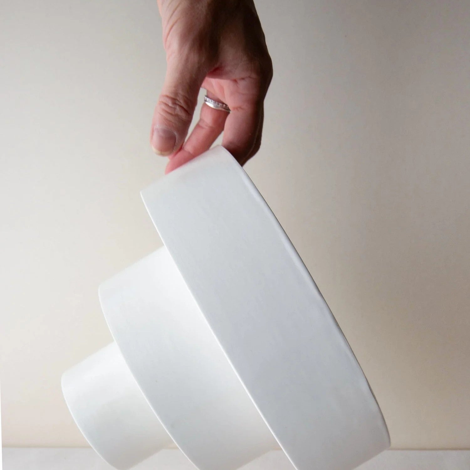 A hand holds the STACK bowl Large sideways, showing its three tiers