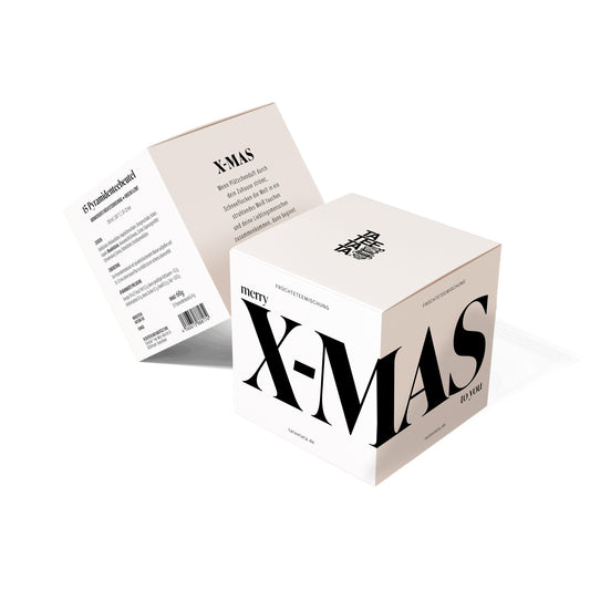 Teewürfel «X-MAS» von TaTeeTaTa – crèmefarbener Würfel mit grossem schwarzem Schriftzug «merry X-MAS to you», daneben die aufgeklappte Verpackung mit Zutaten und Weihnachtstext