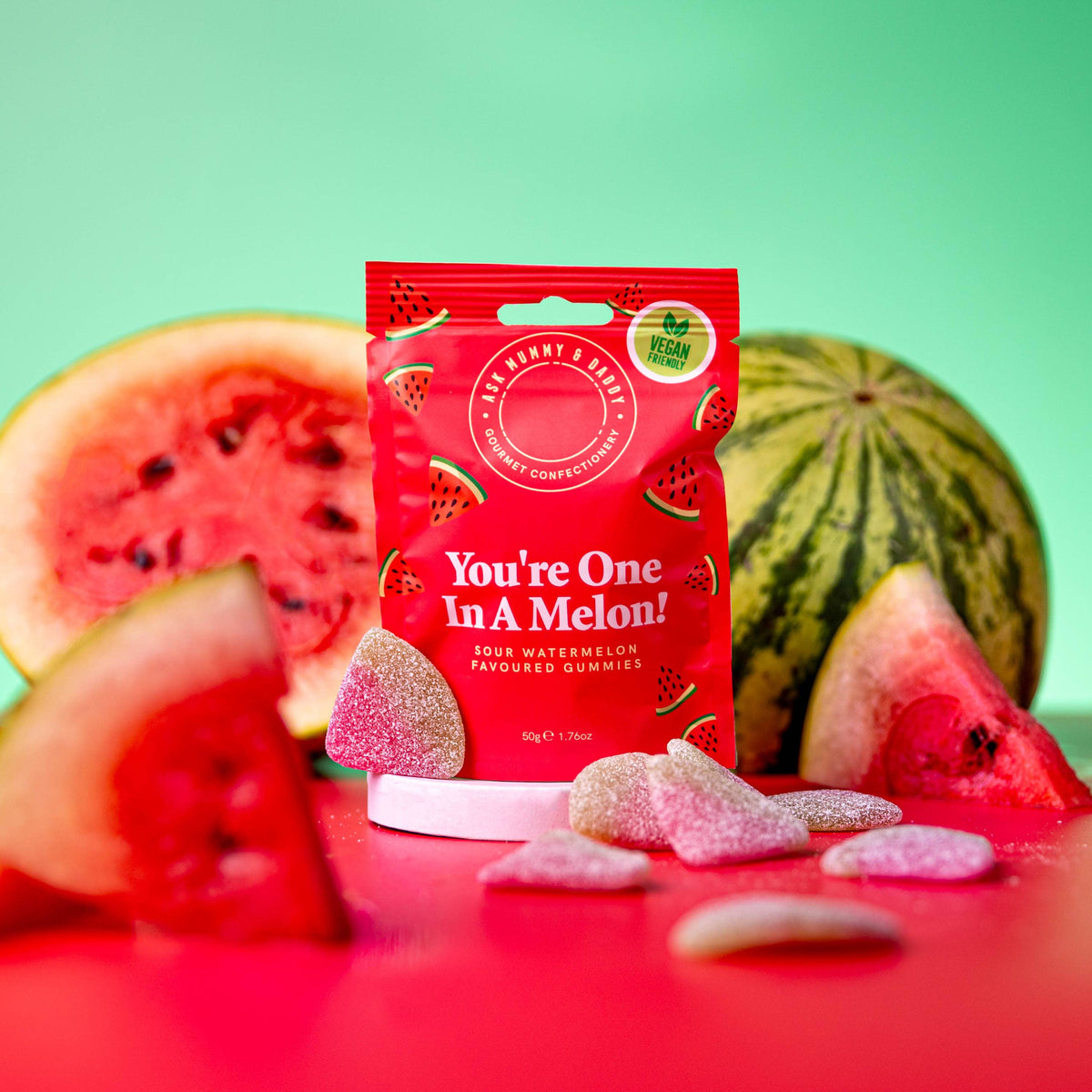 NaniManu Gummis «You’re One In A Melon!» (Ask Mummy & Daddy) – roter Beutel zwischen aufgeschnittenen Wassermelonen