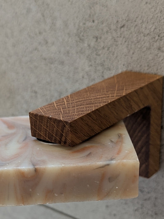 Nahaufnahme des Eichenwinkels an der Wand: Das runde Metallplättchen steckt in der Seife, der Magnet hält sie. Motscho.ch