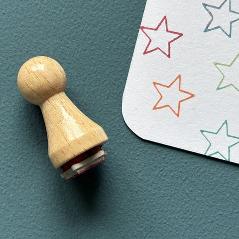 Mini-Stempel «Sternlinie» von Mare di Maria – Holzstempel neben bunten Stern-Konturen in Rot, Orange, Grün und Türkis auf weisser Karte